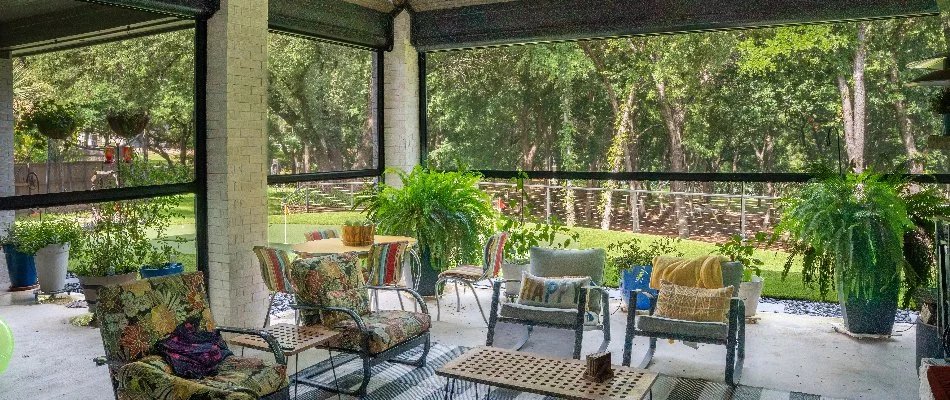 Motorized screens on a patio in Kingwood, TX, with plants and furniture.